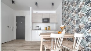A modern kitchen with white cabinets, a microwave, and a coffee maker. - Apartment in Rewal near Baltic Sea Beach (Rewal)