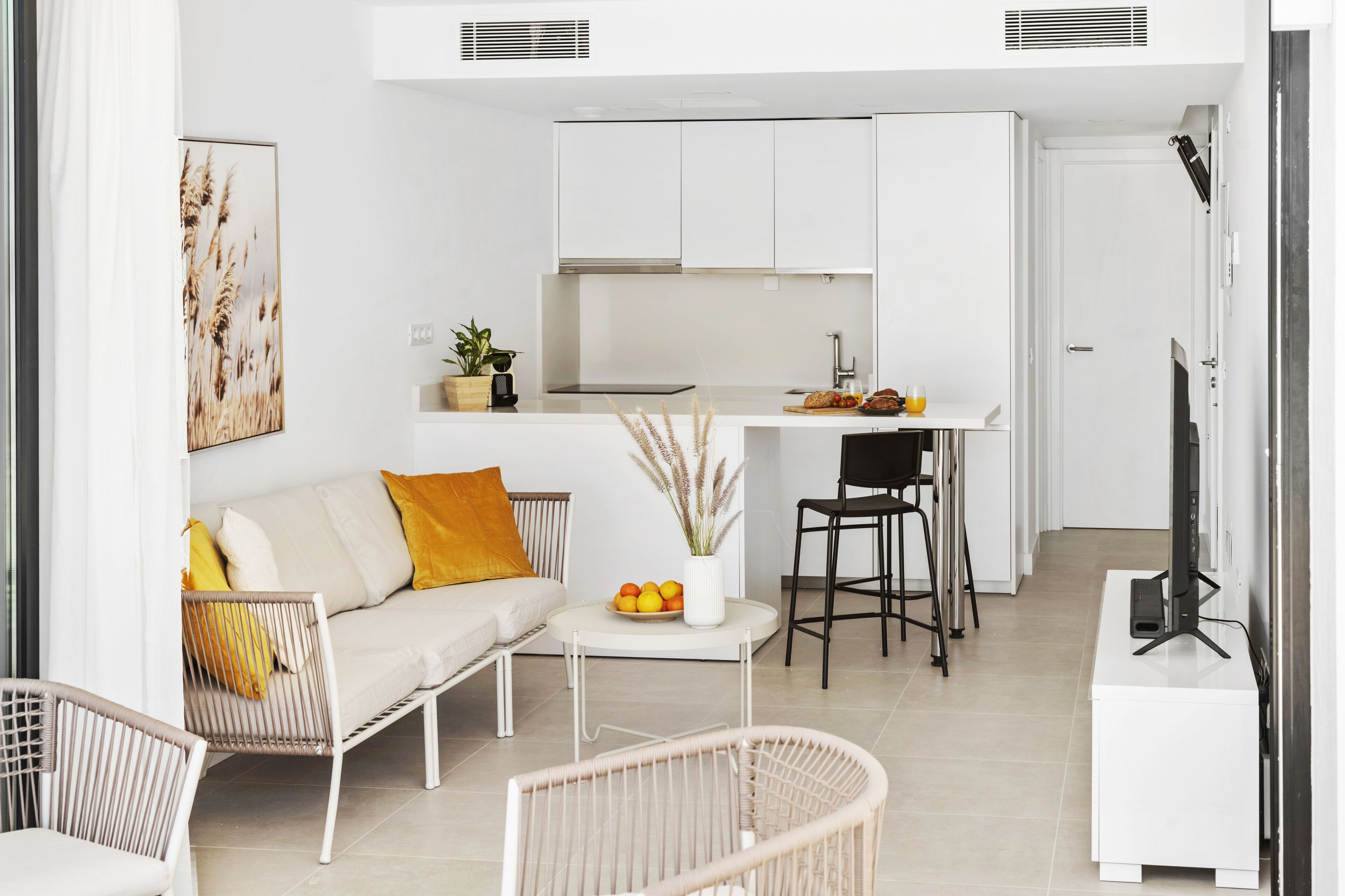 Eine moderne Wohnung mit Wohnbereich, Küchenzeile und Essbereich.