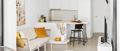 Un apartamento moderno con sala de estar, kitchenette y comedor.