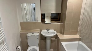 A bathroom with a toilet, sink, and bathtub. - Immaculate 1-bed Apartment in East London (London)