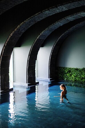 Una piscina interior con techos abovedados y una vista despejada del borde de la piscina.