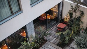 A rooftop garden with stone pathways, potted plants, and outdoor seating.