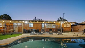A modern house with a swimming pool, outdoor seating, and a well-lit patio area. - Spacious Tucson OASIS 4BD/2.5BA, Sparkling Pool, Billiards, Pingpong, Family-Fun (Tucson)