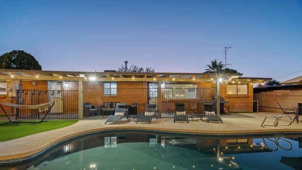 A modern house with a swimming pool, outdoor seating, and a well-lit patio area. - Spacious Tucson OASIS 4BD/2.5BA, Sparkling Pool, Billiards, Pingpong, Family-Fun (Tucson)