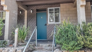 A two-story building with a blue door, numbered 30, and a small window above it. - Warrina 8 | Thredbo | Large & on the Village flat (Thredbo)
