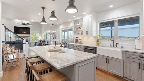 A modern kitchen with a large island, pendant lighting, and a view of the outdoors. -  10 acre property 4 miles from Circuit of the Americas (Del Valle)