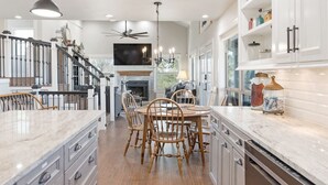 A spacious kitchen with a central island, wooden chairs, and a ceiling fan. -  10 acre property 4 miles from Circuit of the Americas (Del Valle)