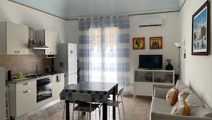 A compact living space with a kitchen, dining area, and seating area. - Appartement en Sicile Près de la mer Pour 1-6 Personnes Avec Terrasse et Wifi (Balestrate)