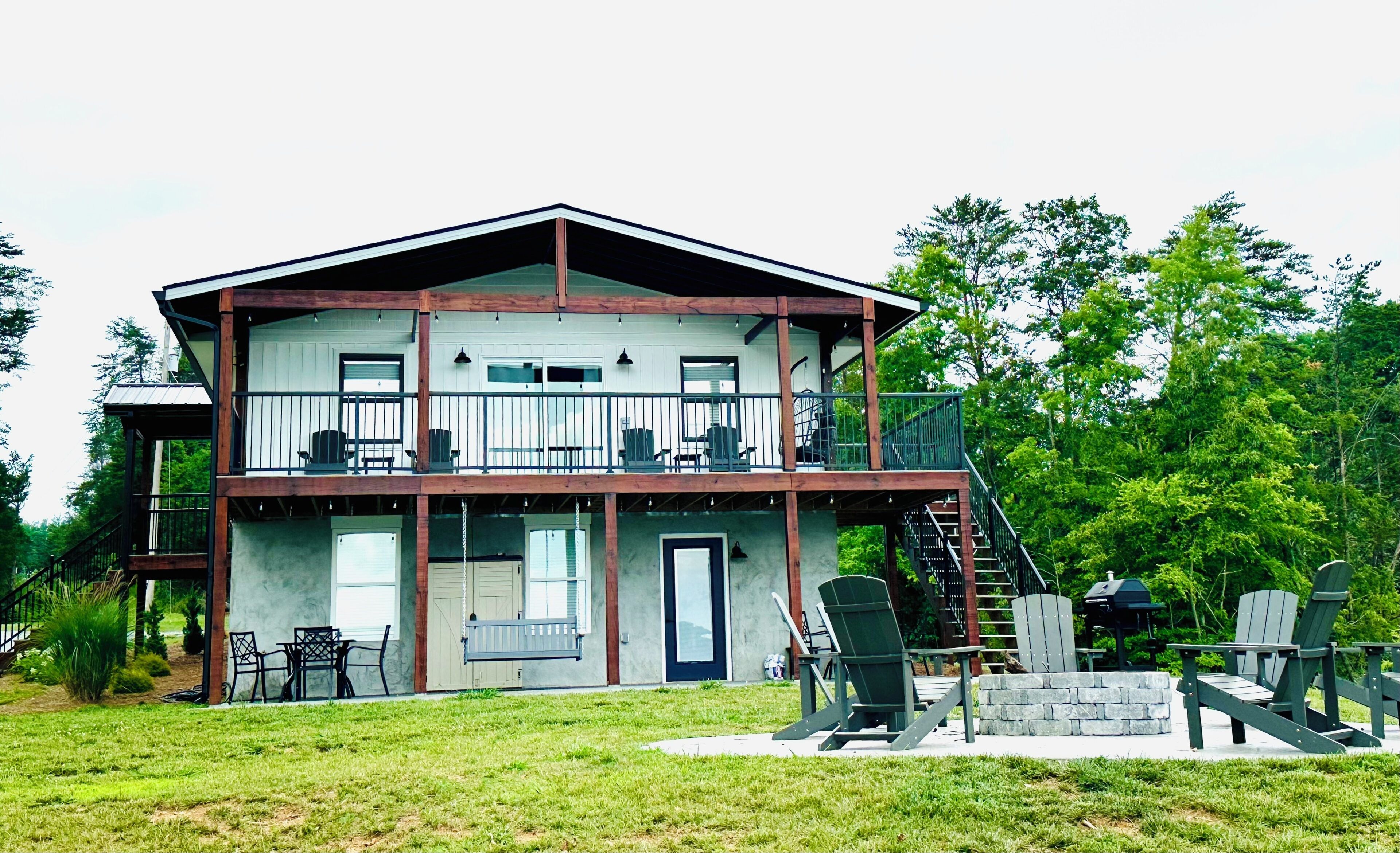 A two-story building with a balcony, outdoor seating, and a staircase leading to the upper level.