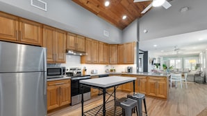 A modern kitchen with wooden cabinets, stainless steel appliances, and a central island.
