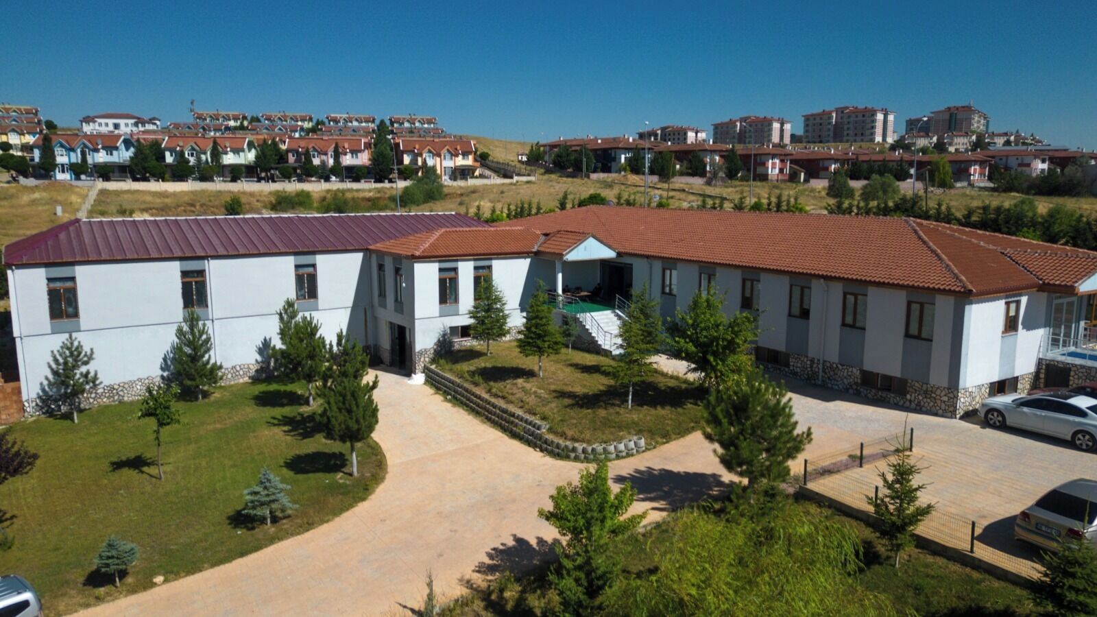 Zona residencial con casas modernas, un camino central y un estacionamiento.