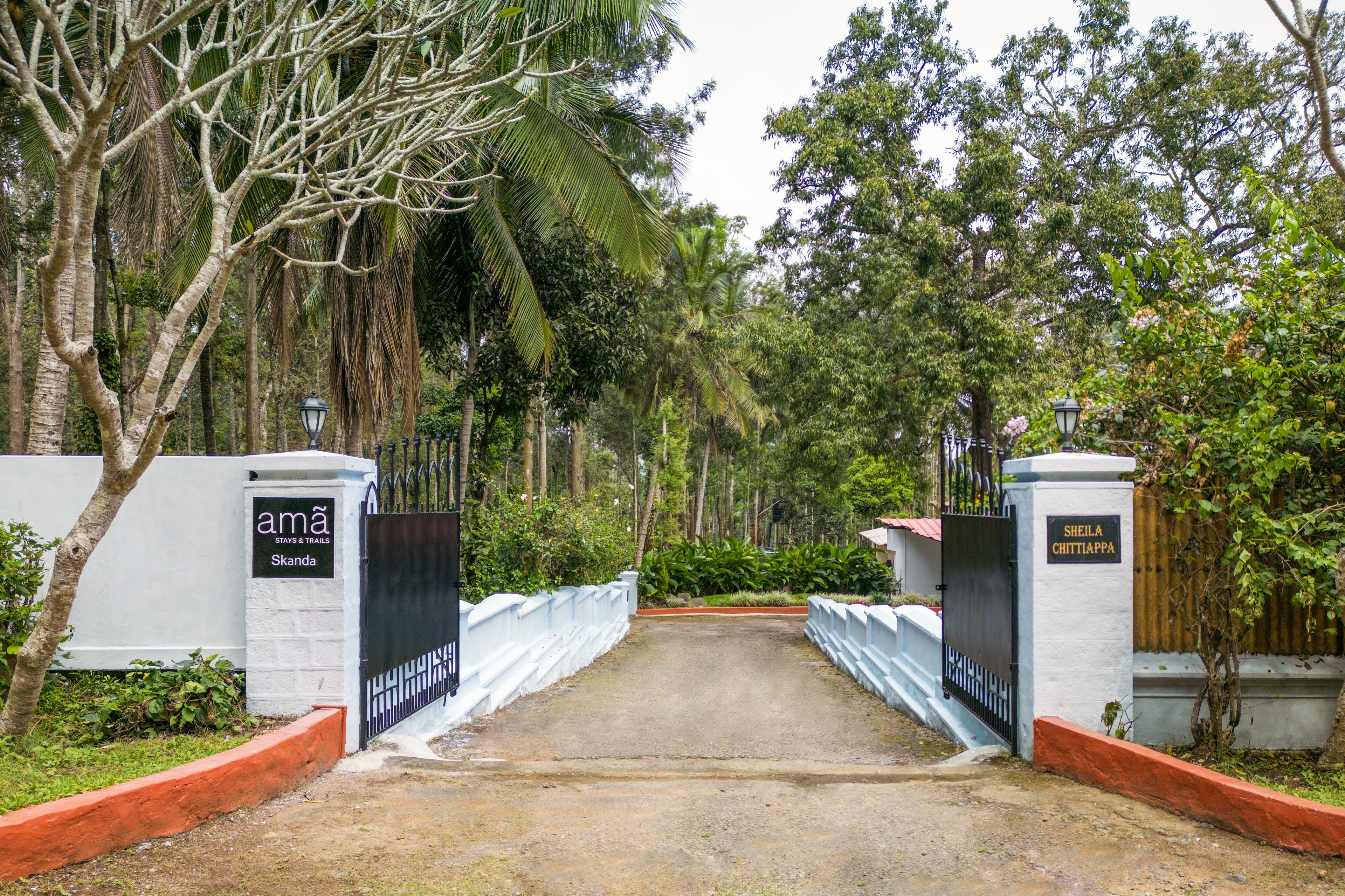 A gated entrance to a property with a sign reading "ama Skanda" and another sign "Sheila Chittappa".