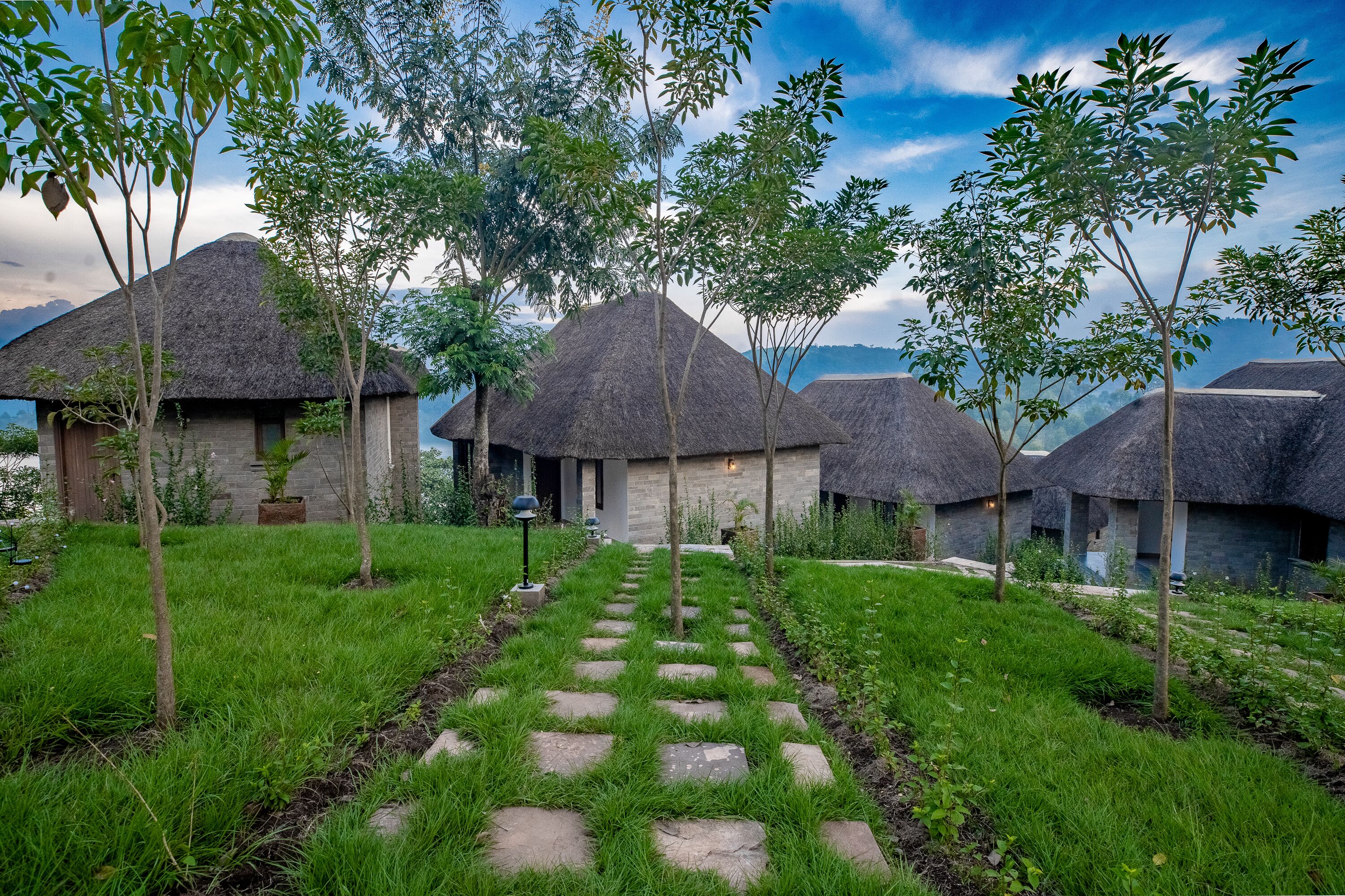 A series of thatched-roof cottages with a stone pathway leading to a central building.