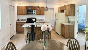 A modern kitchen with wooden cabinets, a central island, and pendant lighting. - Spacious 3 Bedroom Home with yard, pet friendly & sleeps 6! (Oroville)