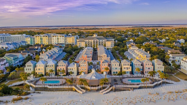 Een groot resort met meerdere gebouwen, een centraal gelegen zwembad en een strand.