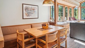 Ein Holztisch mit vier Stühlen, einer Bank und einer Pendelleuchte.