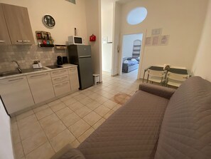 Comfort appartement | Privékeuken | Een koelkast met diepvriezer, een microgolfoven, een kookplaat