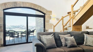 A cozy living room with a stone arch doorway leading to a terrace with outdoor seating. - 2 bedroom accommodation in Carleton, near Skipton (Carleton, near Skipton)