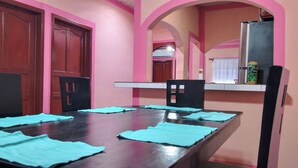 A dining area with a long table, chairs, and blue placemats.