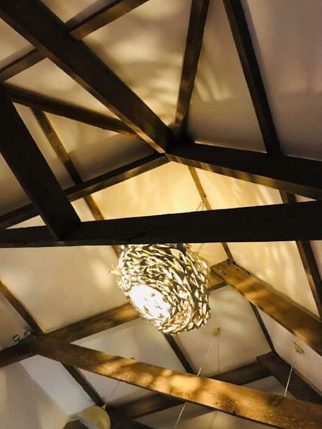 A ceiling with a geometric pattern and a hanging light fixture.