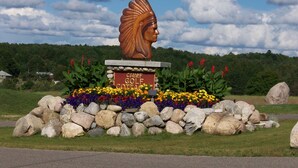 A large wooden sculpture of a Native American headdress with a plaque reading "Chief Golf Cottages". - Fairway to Heaven at Shanty Creek (Bellaire)