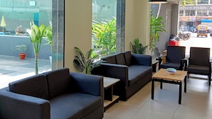 Un espace d’attente moderne, doté de canapés, d’une table basse et de plantes en pot.