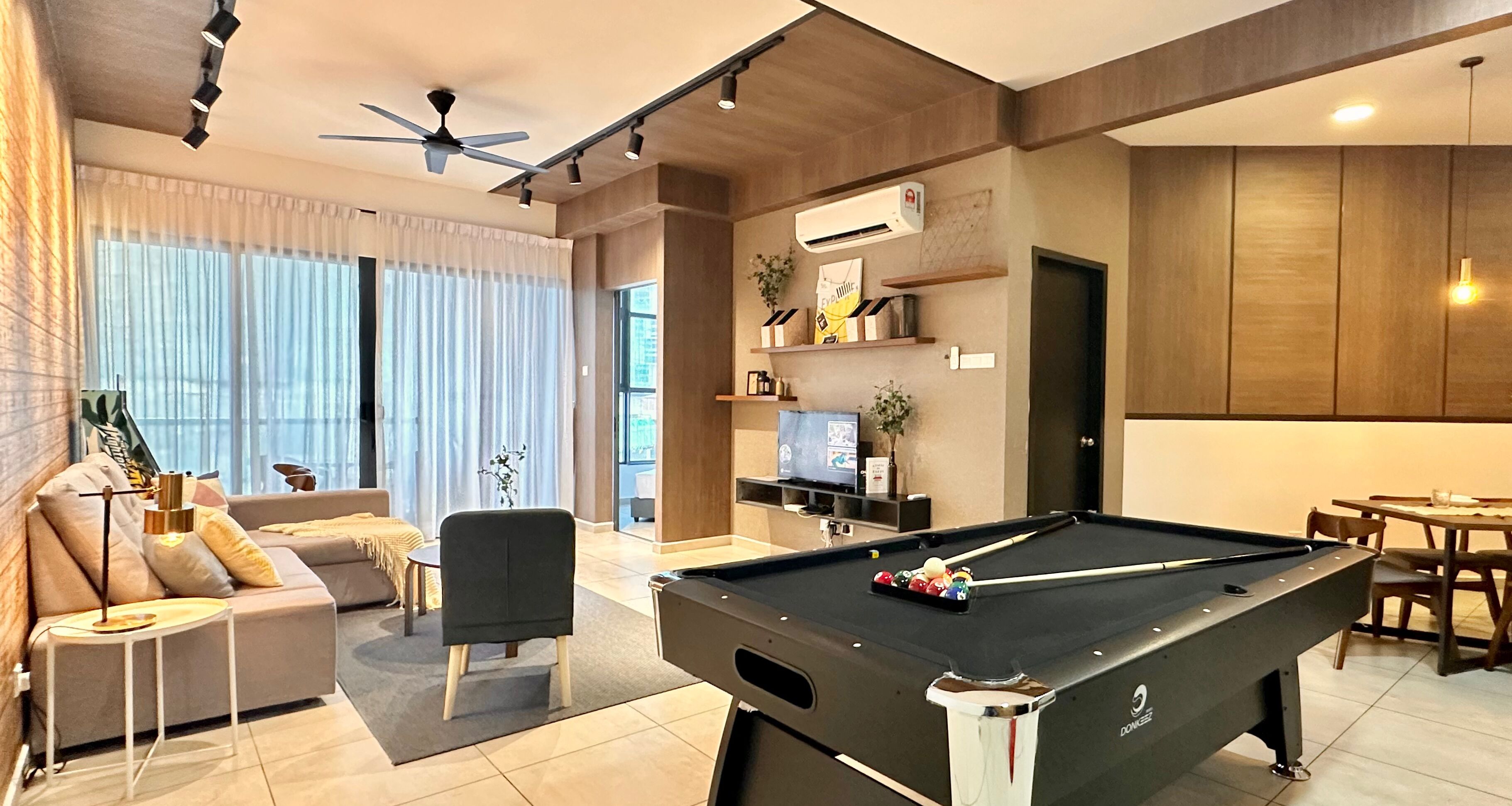 Una sala de estar moderna con una mesa de billar, un sofá y un comedor.