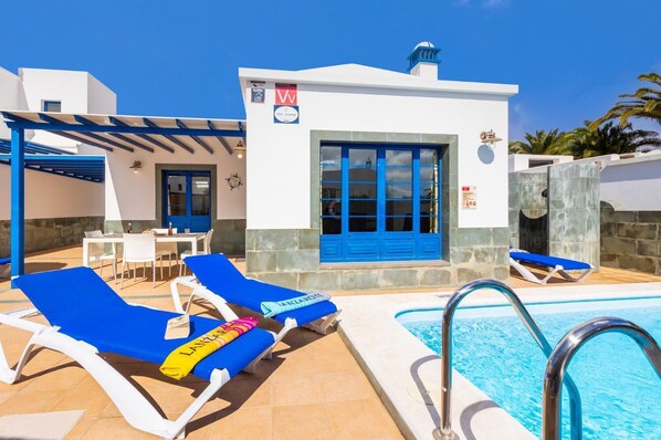 A poolside area with lounge chairs and a pool.