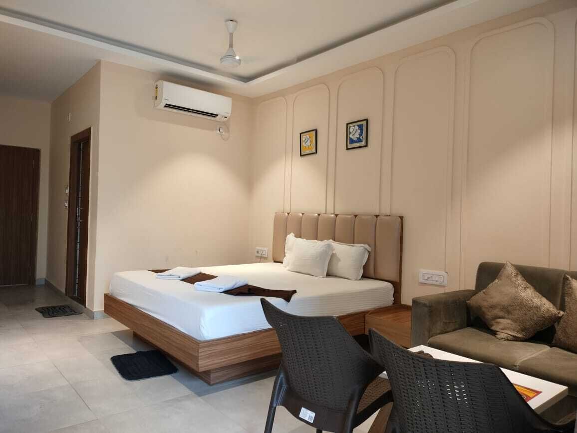 Une chambre d’hôtel équipée d’un lit, d’un canapé, d’une chaise, d’un climatiseur et d’un ventilateur de plafond.