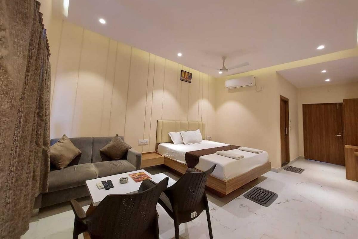 Una habitación de hotel moderna con sofá, cama, escritorio y una silla.