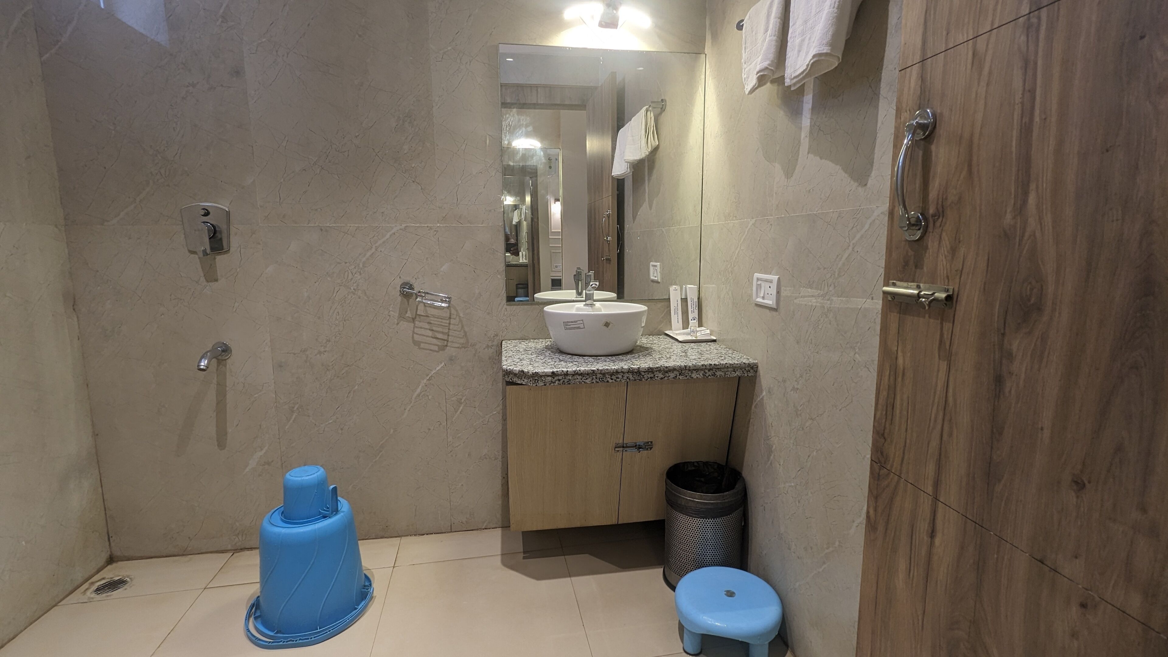 A bathroom with a sink, mirror, and wooden cabinets.