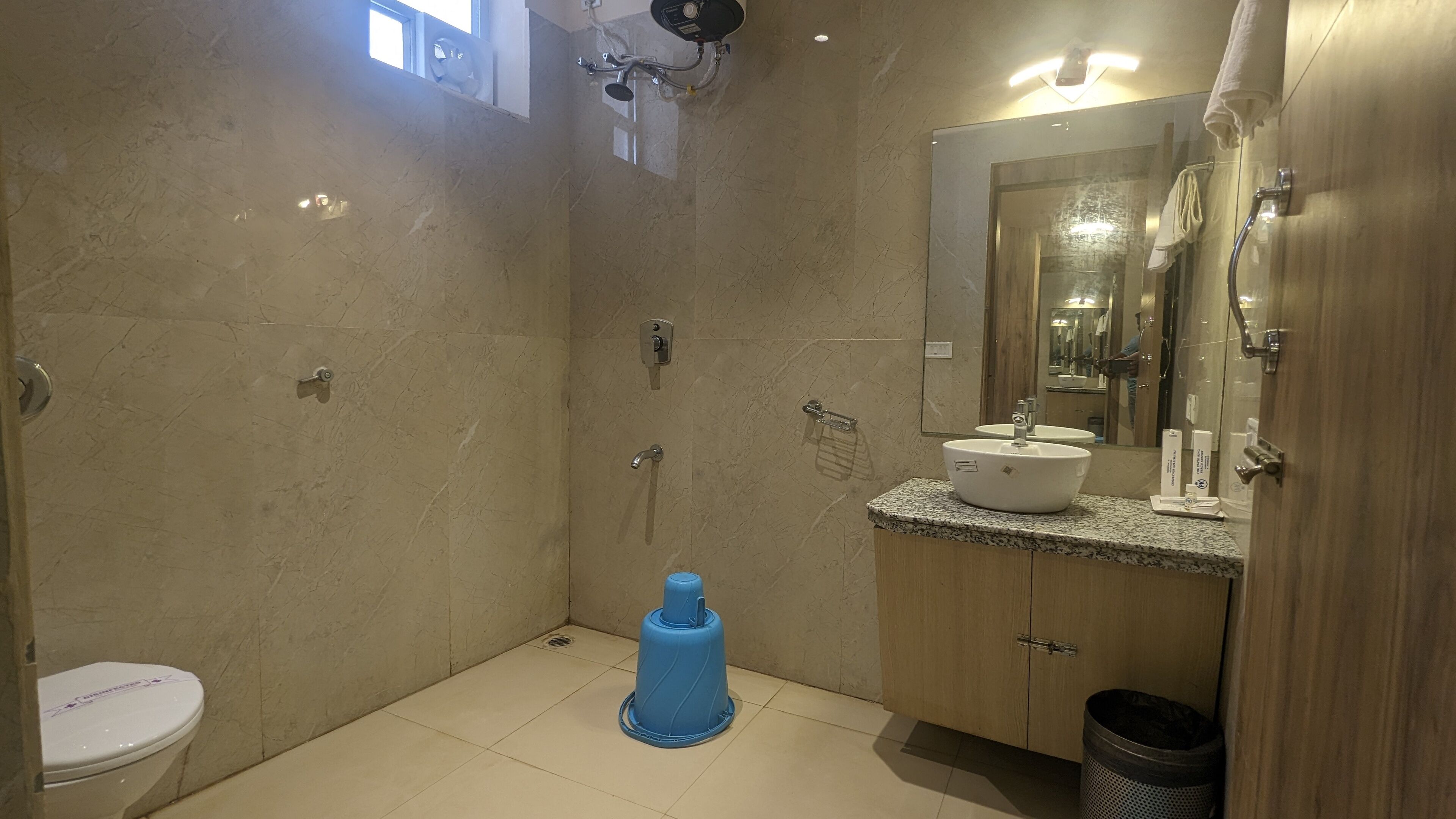 A modern bathroom with a toilet, sink, mirror, and shower.