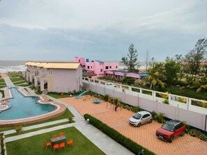 A resort with a swimming pool, a children's play area, and a view of the ocean. - PARTH KING BEACH RESORT (Kanthi)