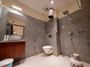 A modern bathroom with a large mirror, a sink, a toilet, and a shower. - PARTH KING BEACH RESORT (Kanthi)
