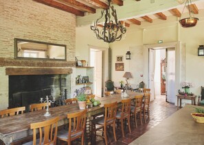 A rustic dining area with a brick fireplace, wooden table, and chairs. - Idyllic French château surrounded by rolling hills- Chateau de Lassalle (Laplume)