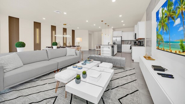 A modern living room with a sofa, coffee table, and a kitchen in the background. - Fabulous Fun 8 Bed Pool Home with Game Room-4297LA (Davenport)