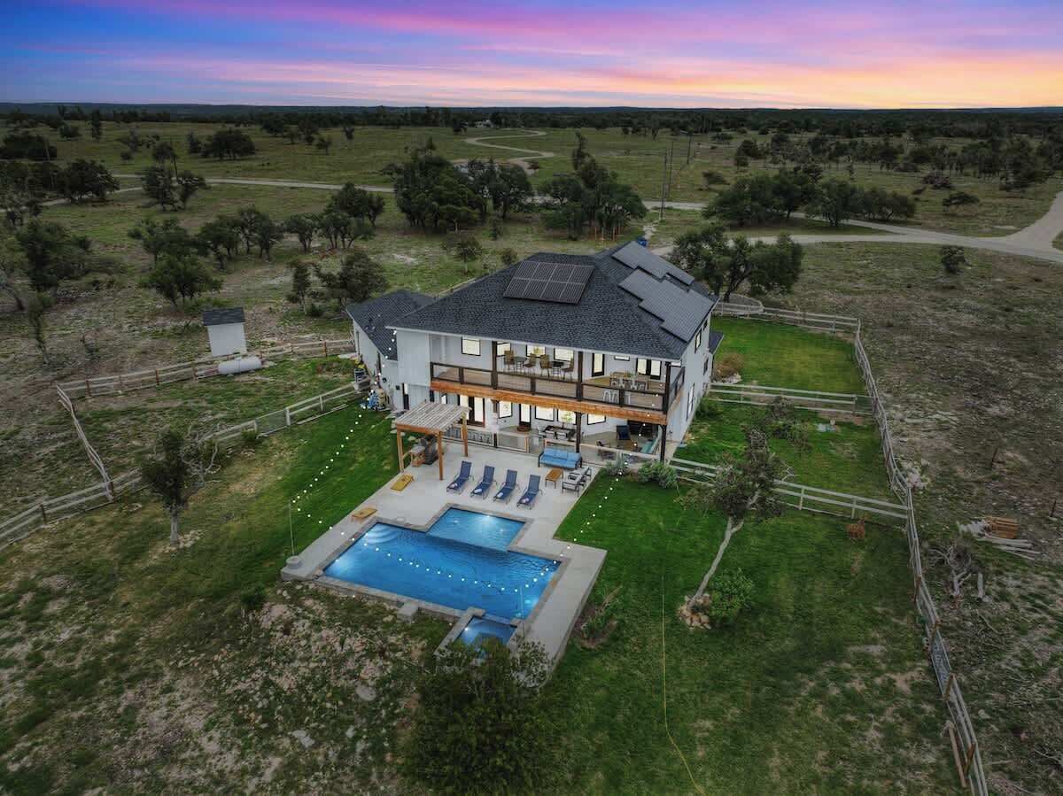 Una casa grande y moderna con piscina y zona de estar al aire libre.