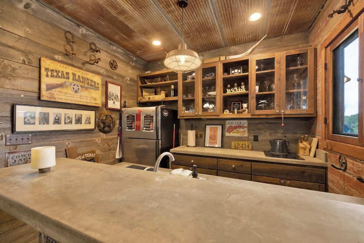 Una cocina rústica con armarios de madera, una isla grande y decoración vintage.