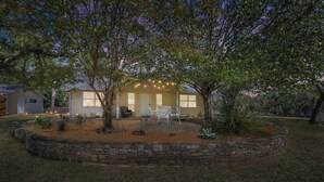 A house with a stone patio, outdoor seating, and string lights. - Weitz Retreat (Fredericksburg)