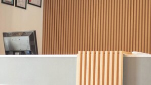 A reception desk with framed certificates on the wall, a wooden slat partition, and a computer monitor. - Suffix Retreat - Stay, Dive & Explore Fuvahmulah (Fuvahmulah)