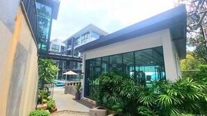 Surrounded by lush greenery, this building offers a serene outdoor seating area with umbrellas.