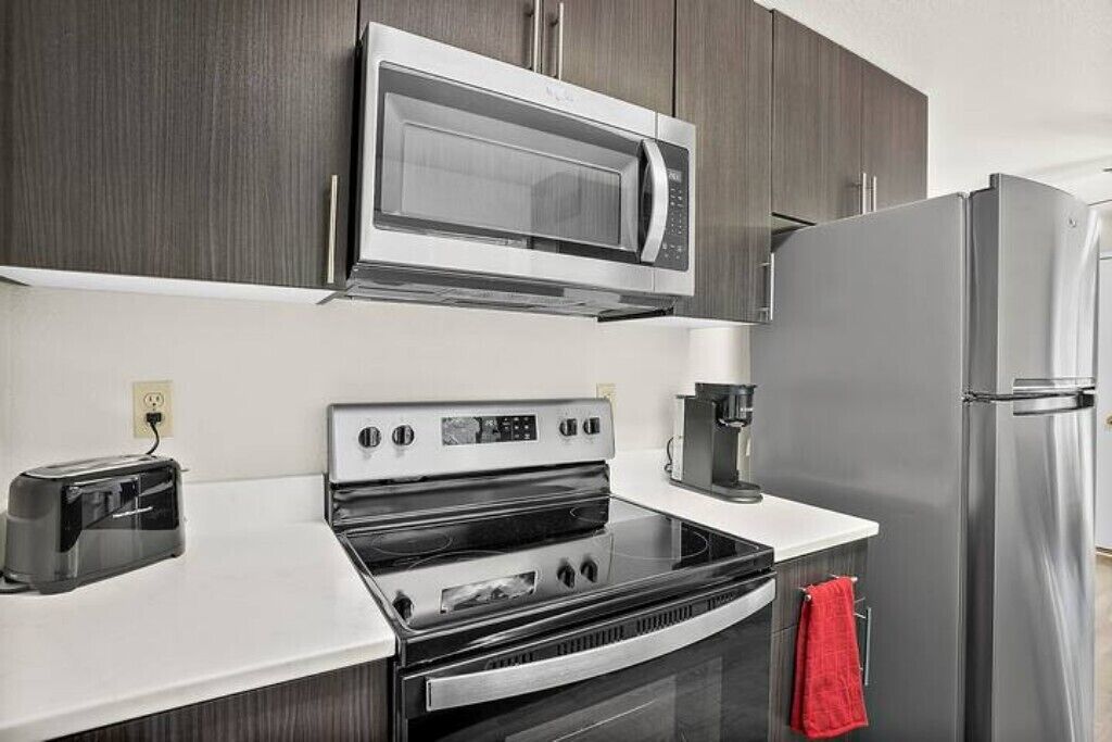 Eine moderne Küche mit Mikrowelle, Backofen und Kühlschrank.