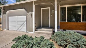 Une maison de plain-pied avec un garage, une porte d’entrée et un petit porche.