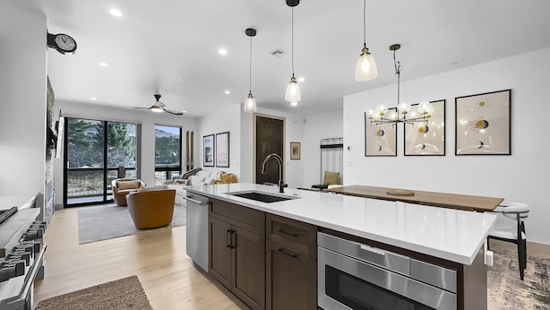 A modern kitchen with a large island, stainless steel appliances, and pendant lighting. - Modern Townhome, Amazing views from the Rooftop Hot tub 541 (Silverthorne)