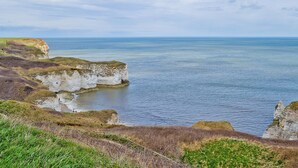 Un paysage côtier avec des falaises et une mer calme.
