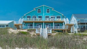 A large, two-story beachfront house with multiple balconies and a staircase leading to the upper level. - 5BR, Ocean Front, 1/2 Duplex! (Emerald Isle)