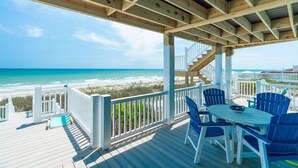 A wooden deck with a table and chairs, overlooking a beach. - 5BR, Ocean Front, 1/2 Duplex! (Emerald Isle)