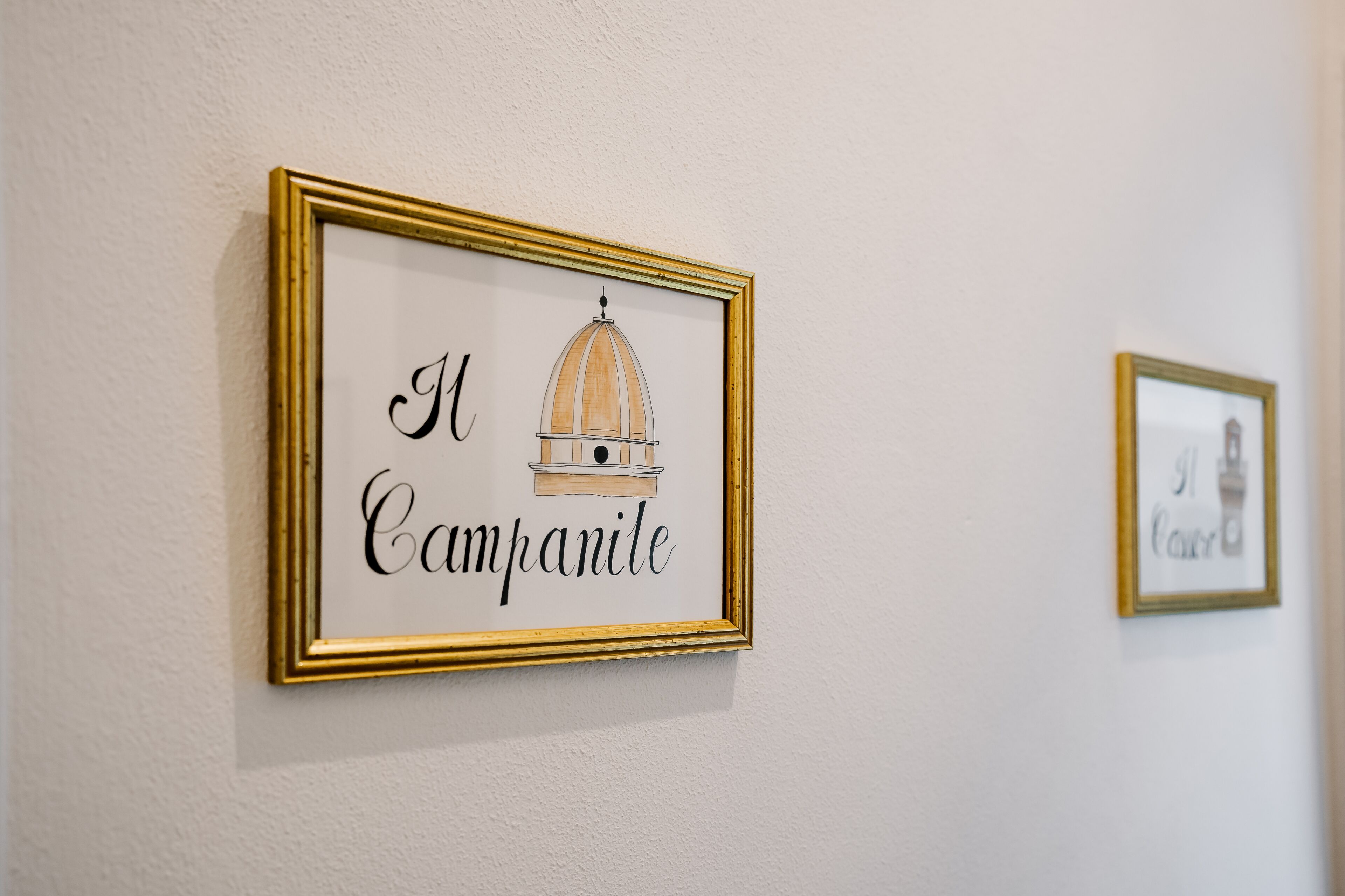 Ein gerahmtes Kunstwerk mit dem Schriftzug „Il Campanile“ und einer Zeichnung eines Glockenturms.