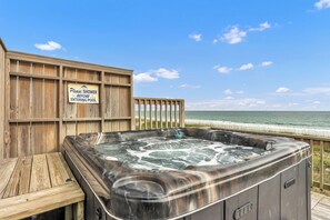 A wooden deck with a hot tub and a sign instructing to shower before entering the pool. - Hot TUB & Pet Friendly, Ocean Front, Covered Decks! (Emerald Isle)