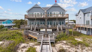 A two-story beachfront house with a wooden deck and multiple balconies. - 4BR Ocean Front - King MBR with Views! (Emerald Isle)